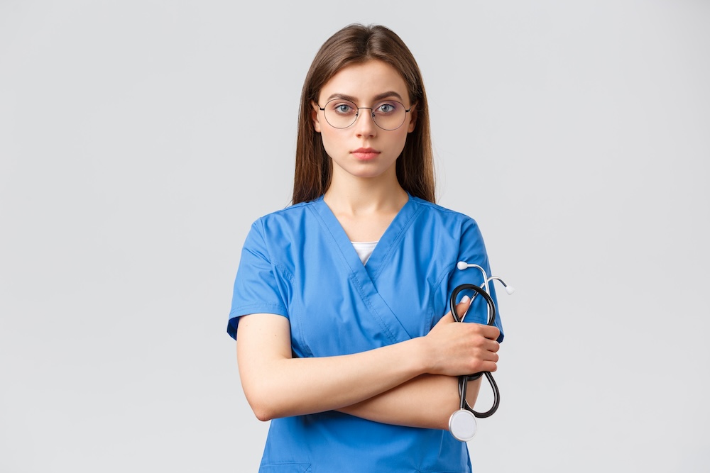 healthcare-workers-medicine-insurance-covid-19-pandemic-concept-serious-determined-professional-female-nurse-doctor-blue-scrubs-holding-stethoscope-wear-glasses-look-confident